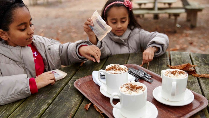 Two children with mugs of hot chocolate at the cafe at Osterley Park